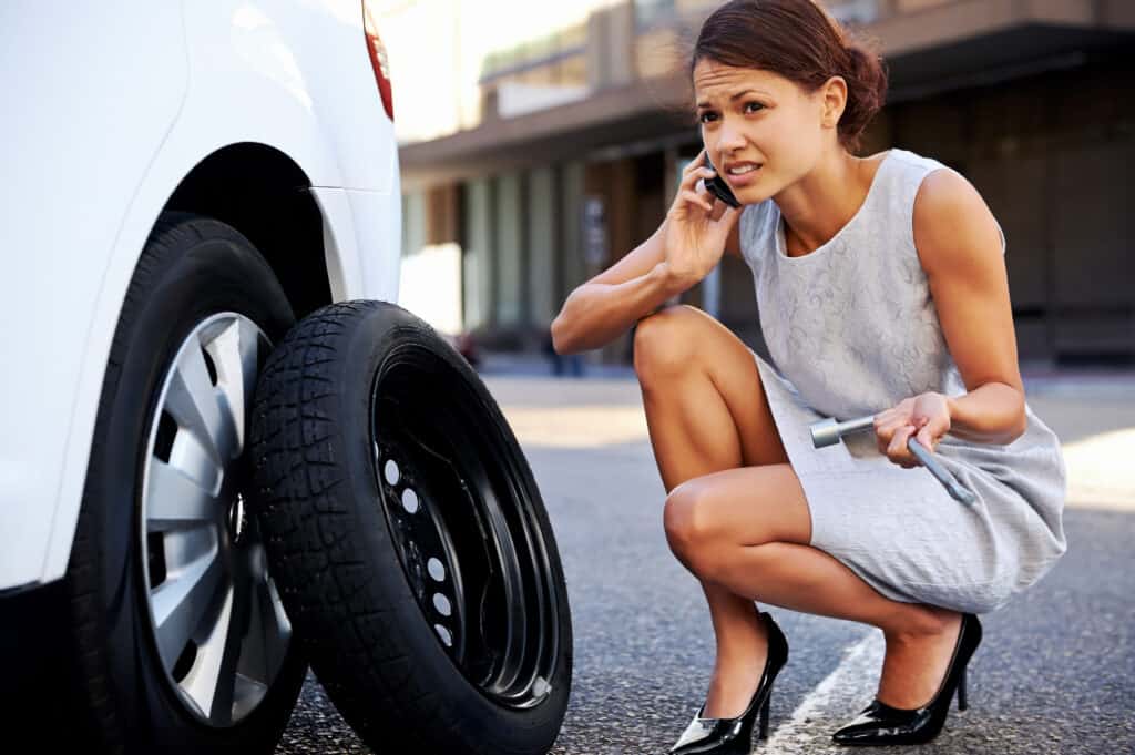 woman and car with flat tire